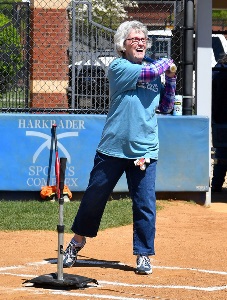 Participant in Softball Hit and Throw event swings bat.
