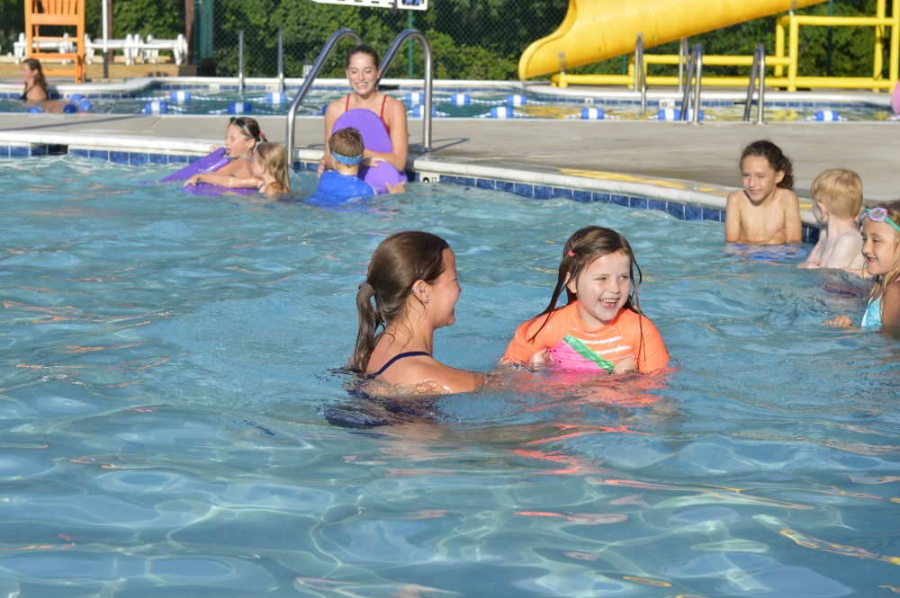 A young swimmer works on water skills with her swim instructor at the Frog Pond Swimming Pool.