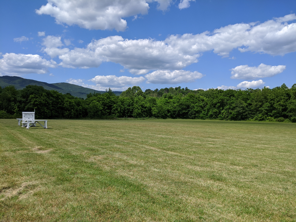 The Montgomery County Model Airplane Club air space is located in the open green space bordered by trees with mountain views.
