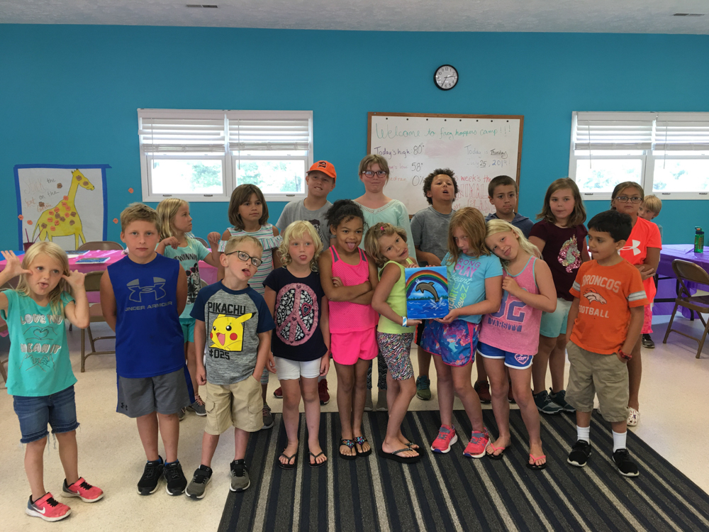 Frog Hoppers Summer Camp participants gather in the Activity Center to show off their artwork.
