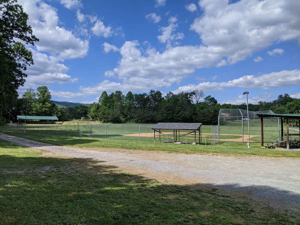 A view of the baseball field, picnic shelter, and playground at McCoy Park on a sunny summer day.