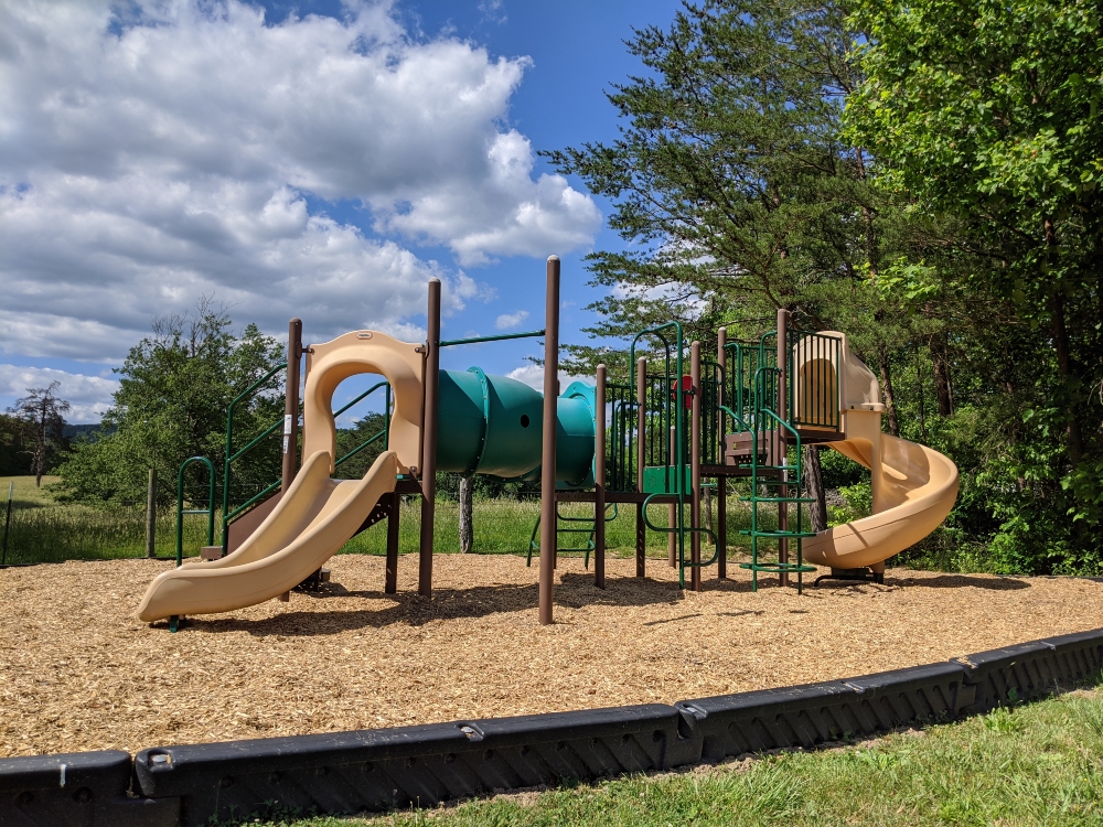 The playground at McCoy Park has two slides and climbing features, with a mulch base.