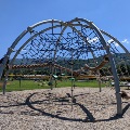 A giant modern climbing dome with many different types of rope at the playground at Creed Fields Park.