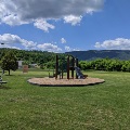 The playground and open green space at Eastern Montgomery Park features a mountain backdrop.