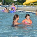 A young swimmer works on water skills with her swim instructor at the Frog Pond Pool.