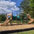The playground at McCoy Park has two slides and climbing features, with a mulch base.