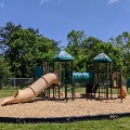 The playground at Plum Creek Park consists of slides and climbing areas on a mulch base.